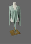 A sage green long-sleeve wrap cardigan displayed on a white mannequin torso with a gold stand, set against a white draped studio backdrop.